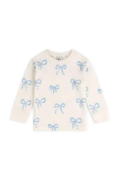 Cream-coloured pyjama top with blue bow patterns on a white background