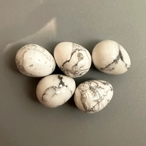 Five marbled crystal eggs on a gray surface