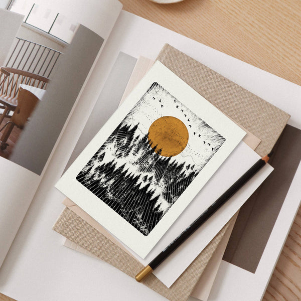 Greeting card with a sun and trees on a desk
