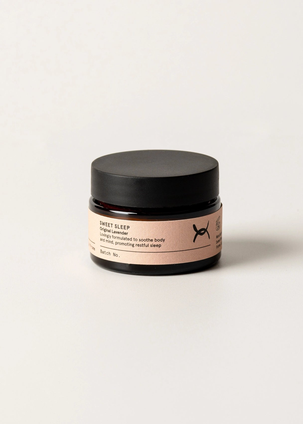 Jar of 'Sweet Sleep' cream with a black lid on a light background