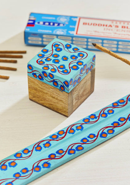 Decorative box with a blue and orange patterned lid on a white surface.