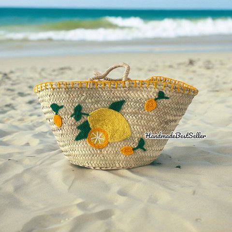 Woven basket with lemon designs on a sandy beach