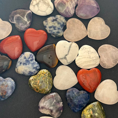 Assorted heart-shaped crystals in various colours on a dark surface