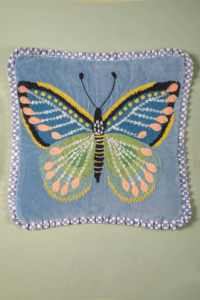Embroidered butterfly design on a blue fabric cushion cover