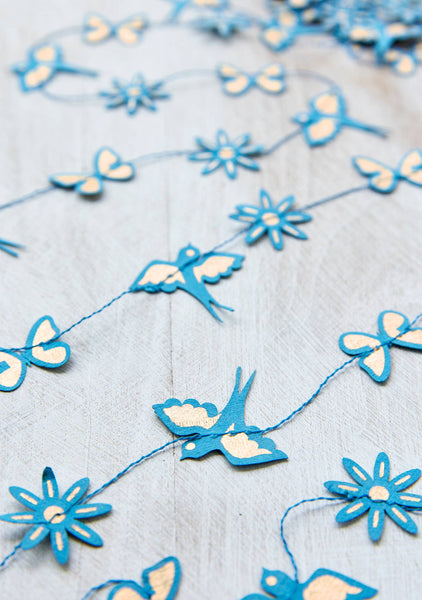 Decorative string with blue butterfly and flower shapes on a light blue background