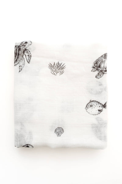 White blanket with black sea-themed patterns on a white background