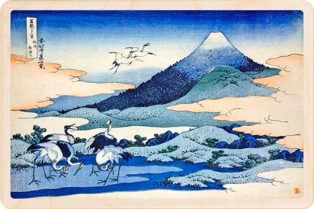 Traditional Japanese woodblock print of cranes by a mountain landscape
