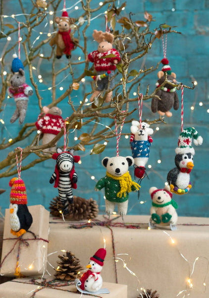 Decorative Christmas ornaments on a branch with lights and presents.
