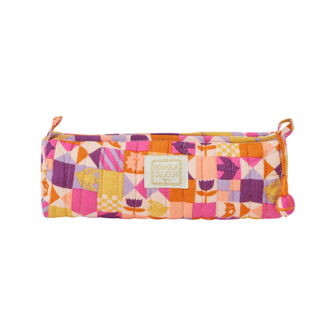 Colorful quilted pencil case with geometric pattern on a white background