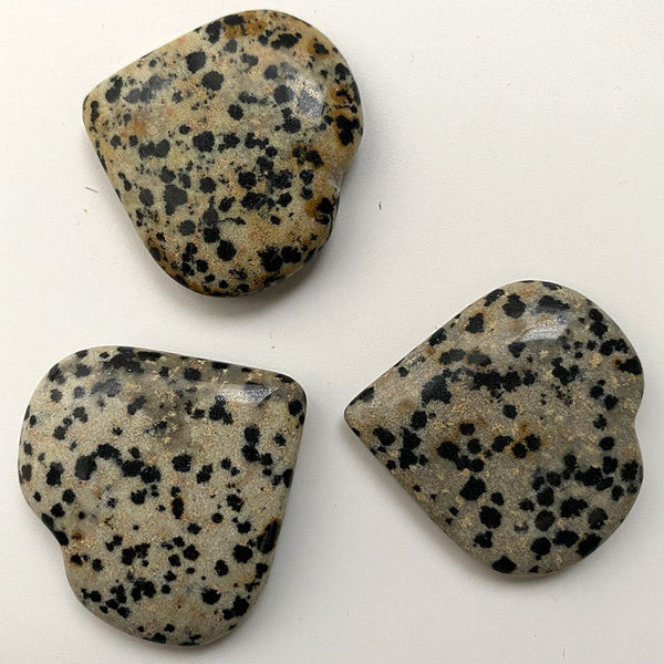 Three speckled dalmation jasper crystals on a white background