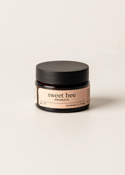 Jar of 'sweet bee. organics' cream on a beige background
