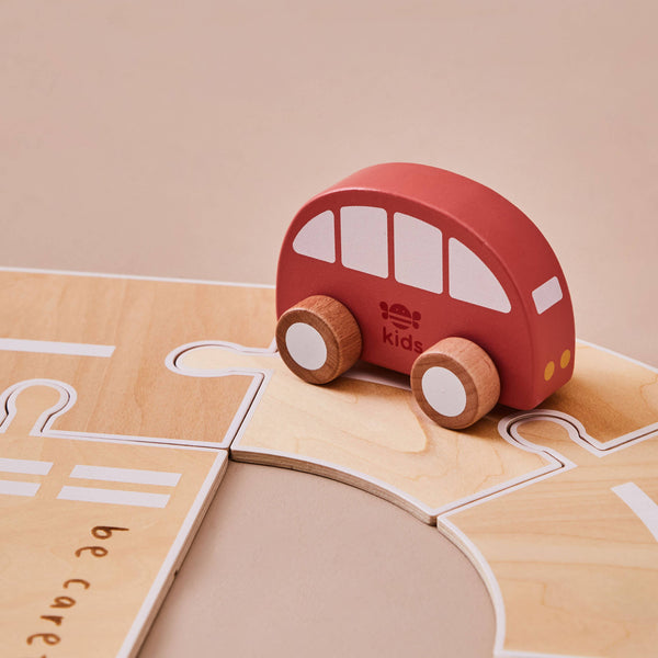 Red toy car on a wooden road with 'kids' branding