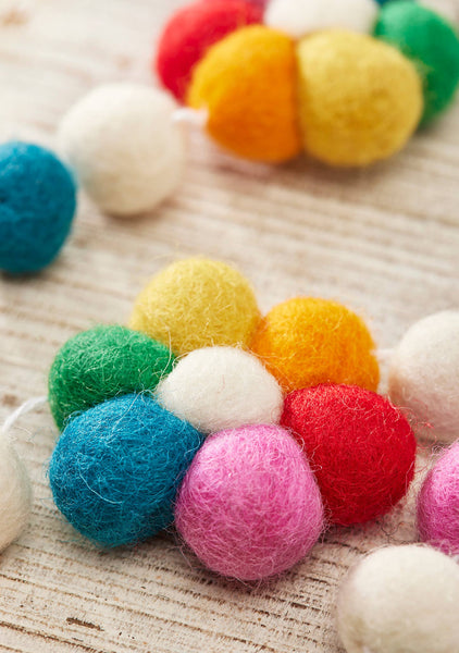 Colourful felt balls on a textured surface