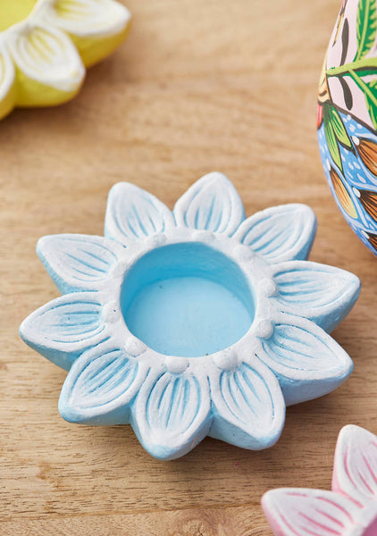 Blue flower-shaped ceramic item on a wooden surface
