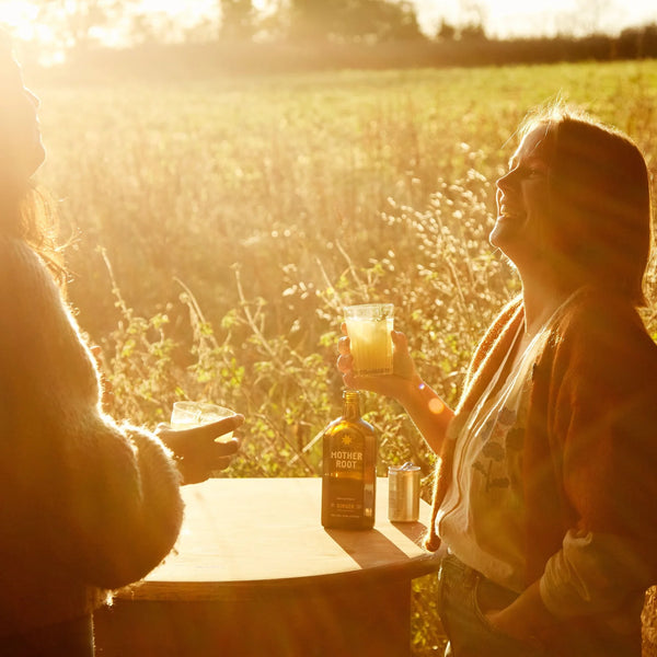 Two people enjoying drinks outdoors with a scenic background