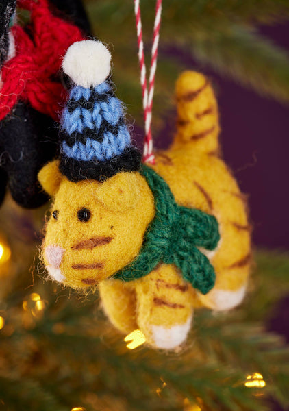 Knitted cat ornament with a blue and black hat on a Christmas tree.