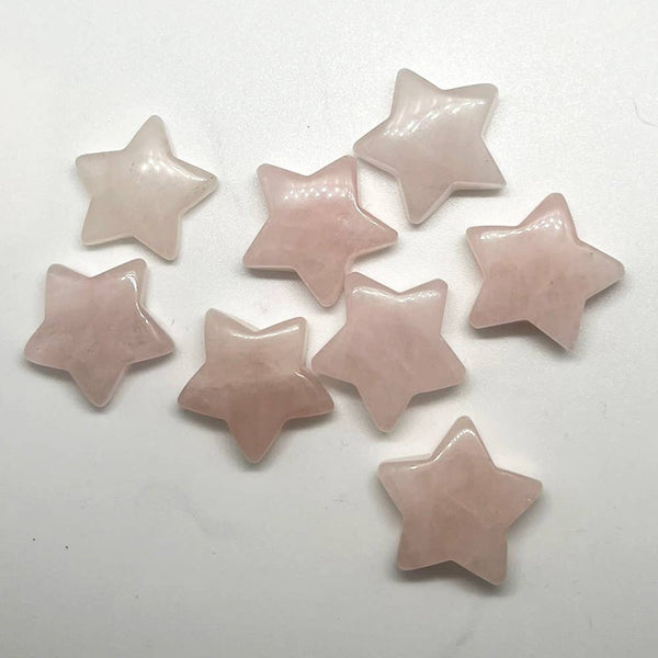 A cluster of star shaped rose quartz gemstones on a white background