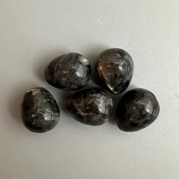 Five dark grey stones on a light grey background