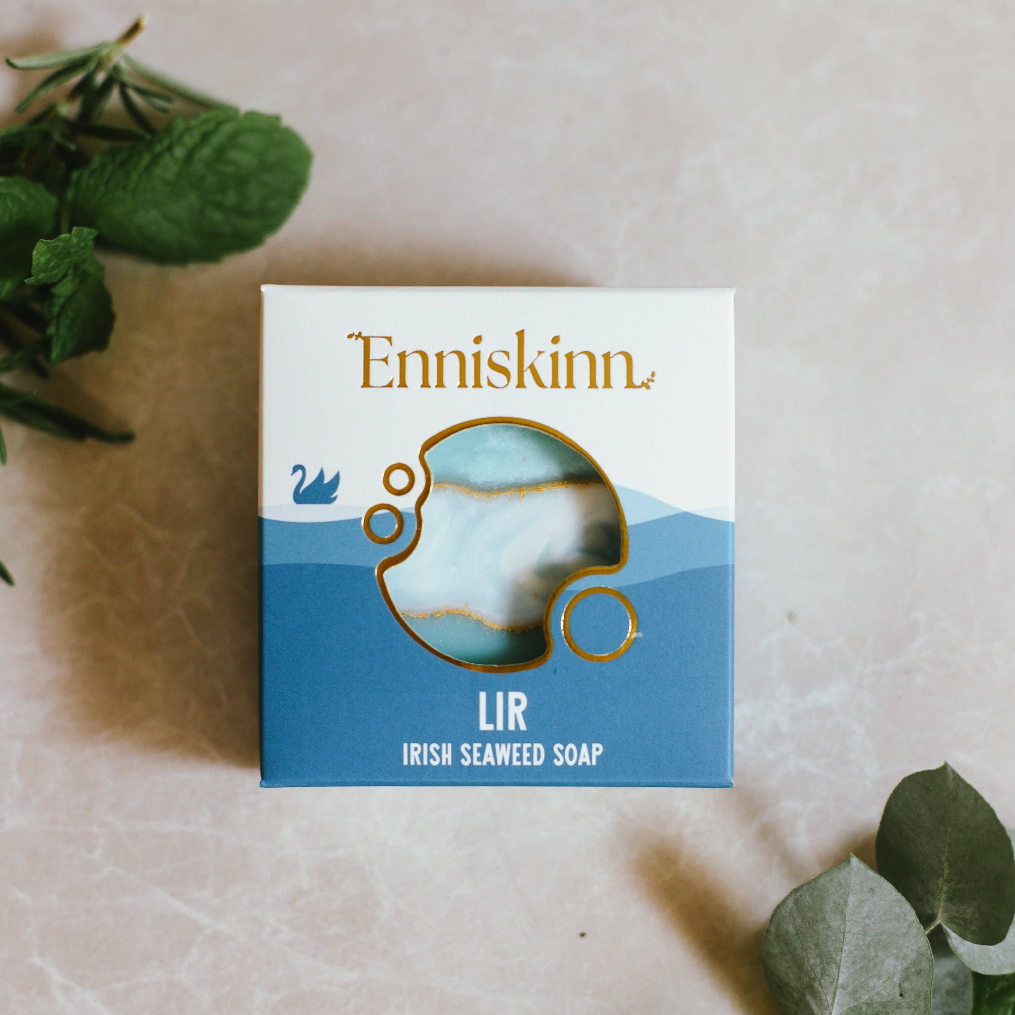 Enniskinn Irish Seaweed Soap packaging on a light surface with green leaves.