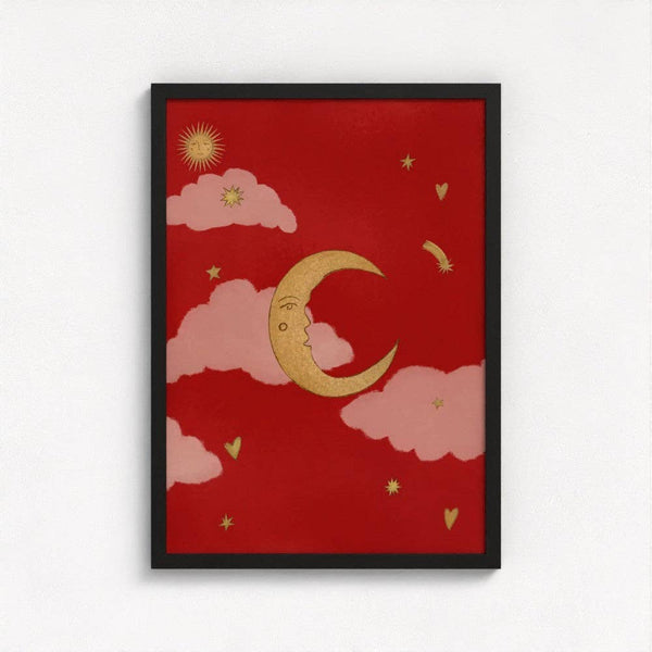Framed artwork with a red background, gold crescent moon, pink clouds, and yellow stars on a white wall.