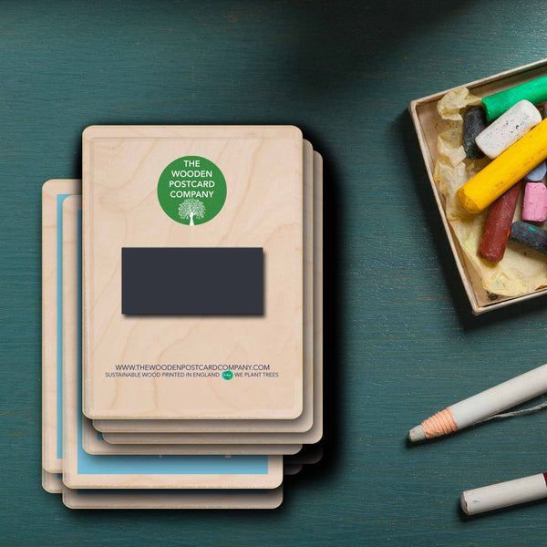 Stack of wooden magnets with a visible brand logo on a teal surface with stationery items.