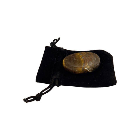 Tiger's eye stone on a black drawstring bag against a white background