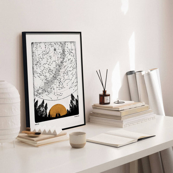 Framed artwork on a desk with books and decor items