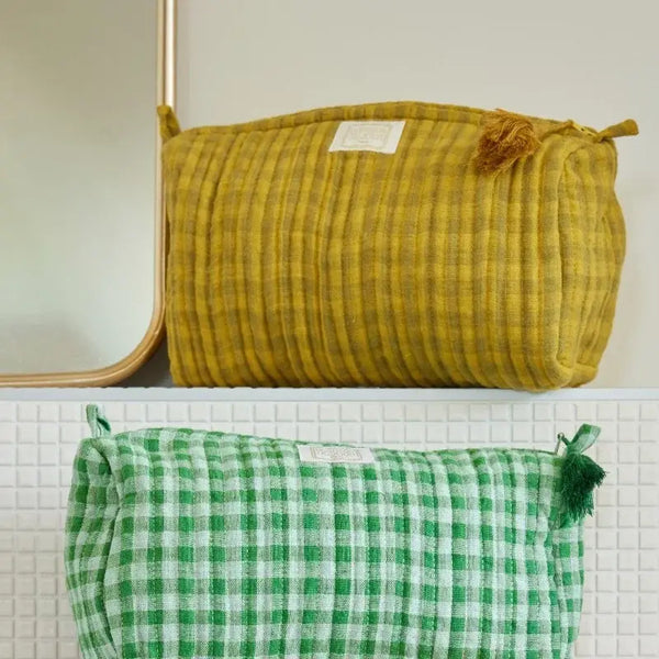 Yellow ribbed pouch and green checkered pouch on a white surface with a neutral background