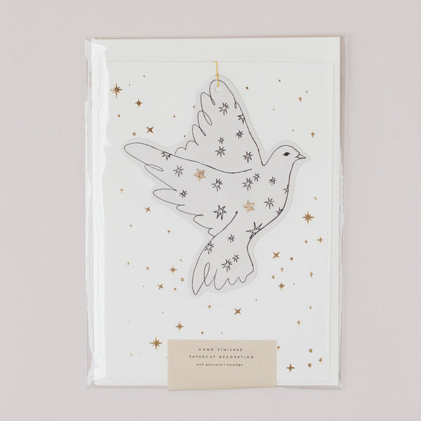 Decorative paper cutout of a dove with stars on a white background