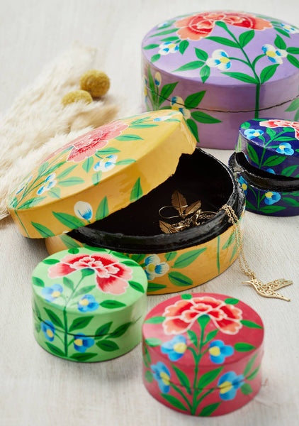 Set of colourful floral-patterned jewellery boxes on a light background
