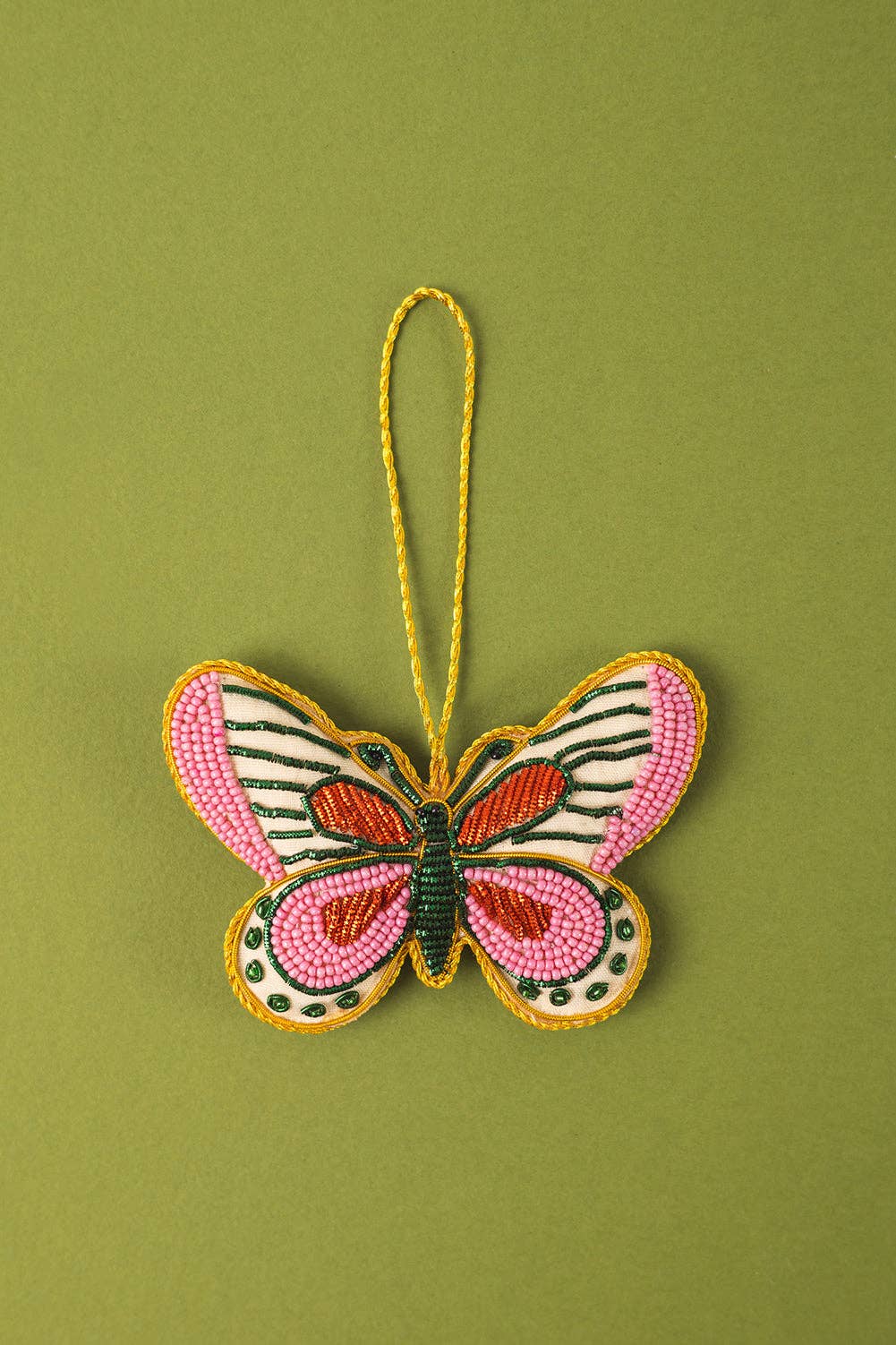 Butterfly-shaped ornament with pink and green design on a green background