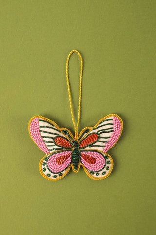 Butterfly-shaped ornament with pink and green design on a green background