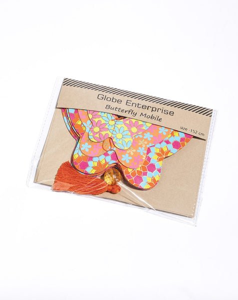 A packaged butterfly-shaped mobile by Globe Enterprise, featuring a colourful floral pattern in pink, orange, yellow, and blue, with a rust-orange tassel, sealed in clear plastic on a white background.