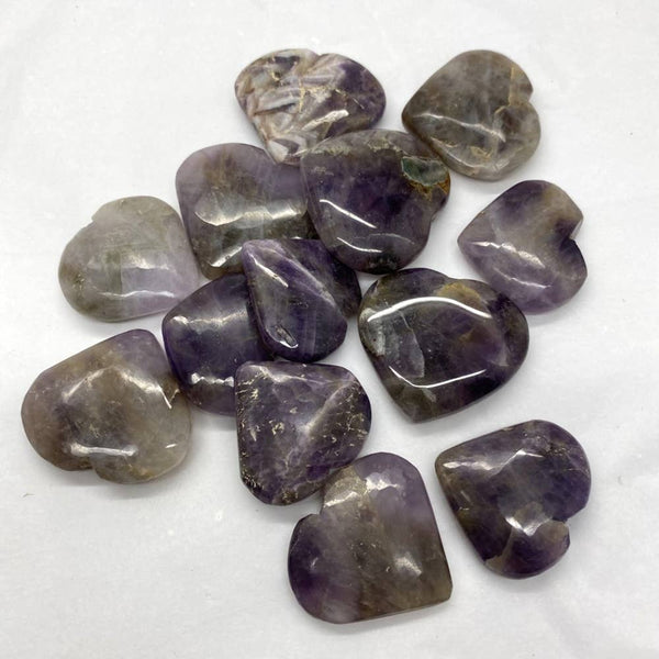 Collection of purple amethyst gemstones on a white background