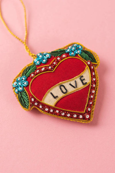 Decorative heart ornament with 'LOVE' text on a pink background