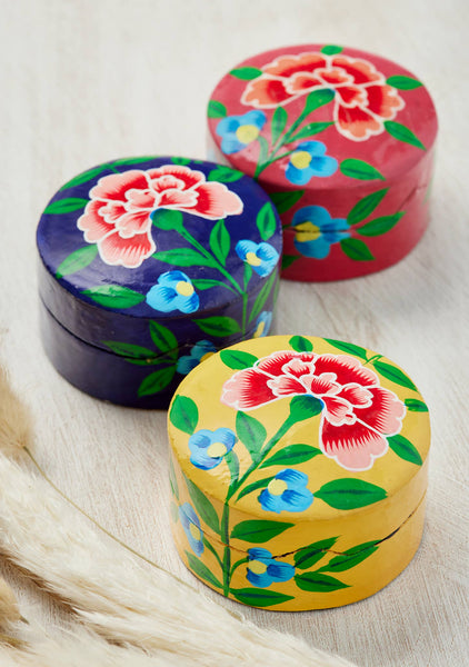 Three colourful wooden boxes with floral designs on a light background