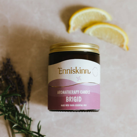 Enniskinn aromatherapy candle labeled 'Brigid' with lemon slices and lavender on a neutral background