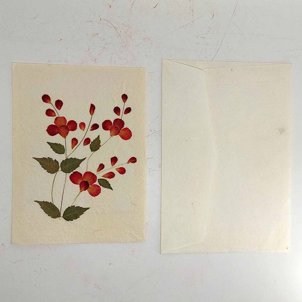 Floral design on a beige card with a matching envelope against a white background