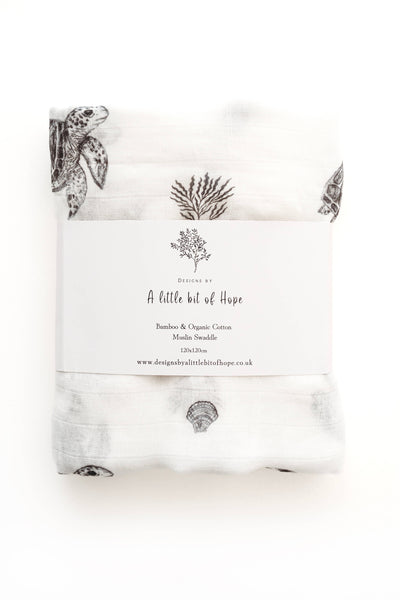 White baby swaddling cloth with black illustrations on a white background
