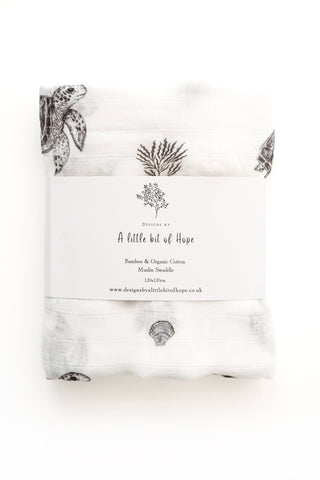 White baby swaddling cloth with black illustrations on a white background