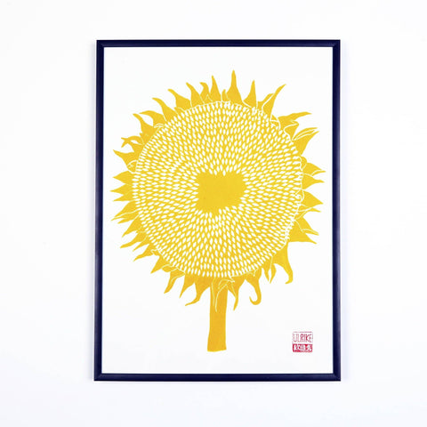 Framed artwork of a yellow sunflower on a white background