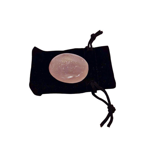 Rose quartz crystal on a black drawstring pouch on a white background