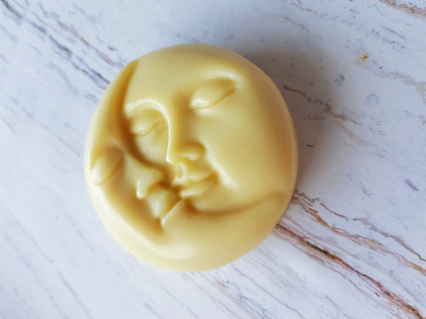 Yellow soap with a face design on a marble surface