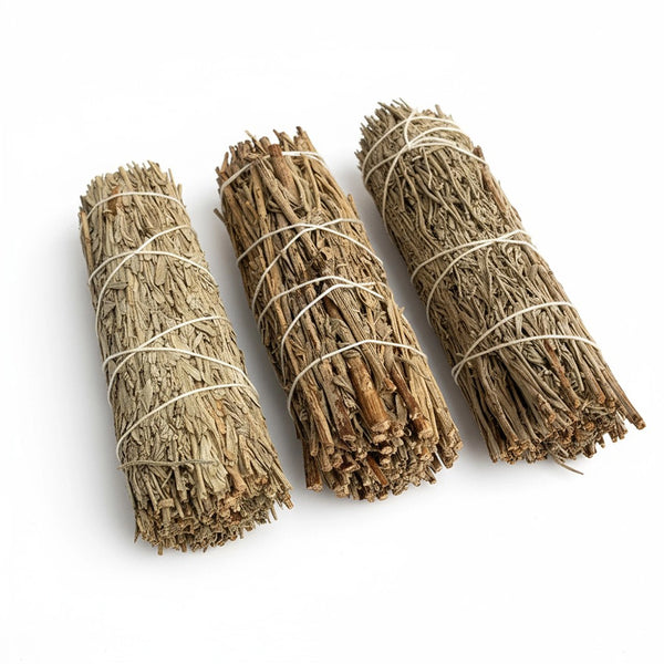 Three bundles of tied sage on a white background