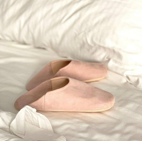 Pair of pink slippers on a soft white surface
