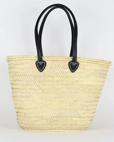 Woven straw tote bag with black handles on a white background