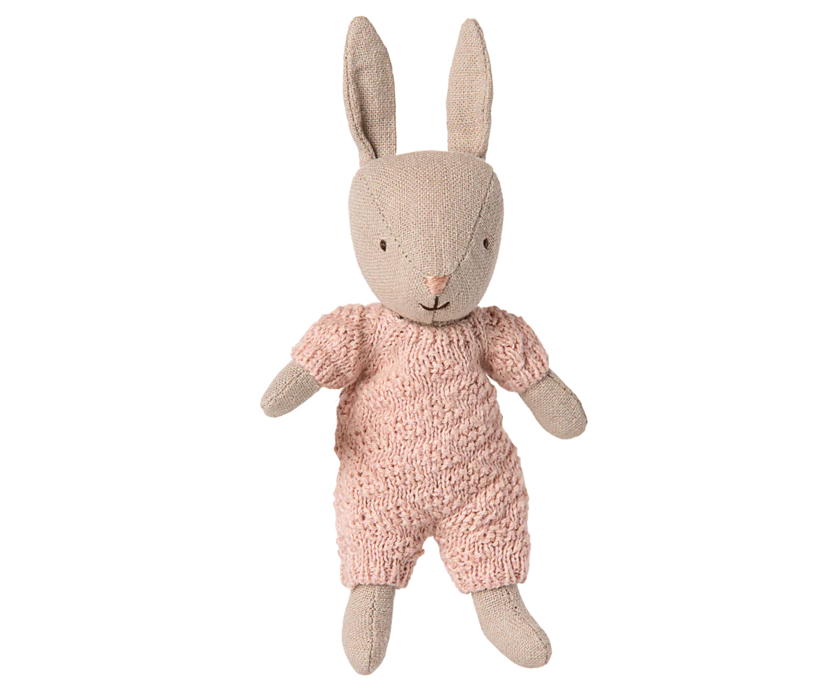 Stuffed rabbit toy wearing a pink outfit on a white background