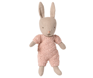 Stuffed rabbit toy wearing a pink outfit on a white background
