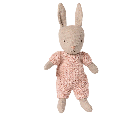 Stuffed rabbit toy wearing a pink outfit on a white background