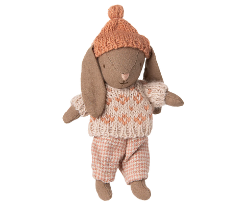 Stuffed rabbit toy wearing a knitted hat and sweater on a white background